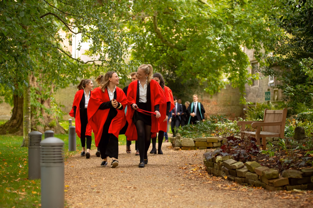 King's Ely Senior Scholars stroll back from the Cathedral through the gardens of The Old Palace.